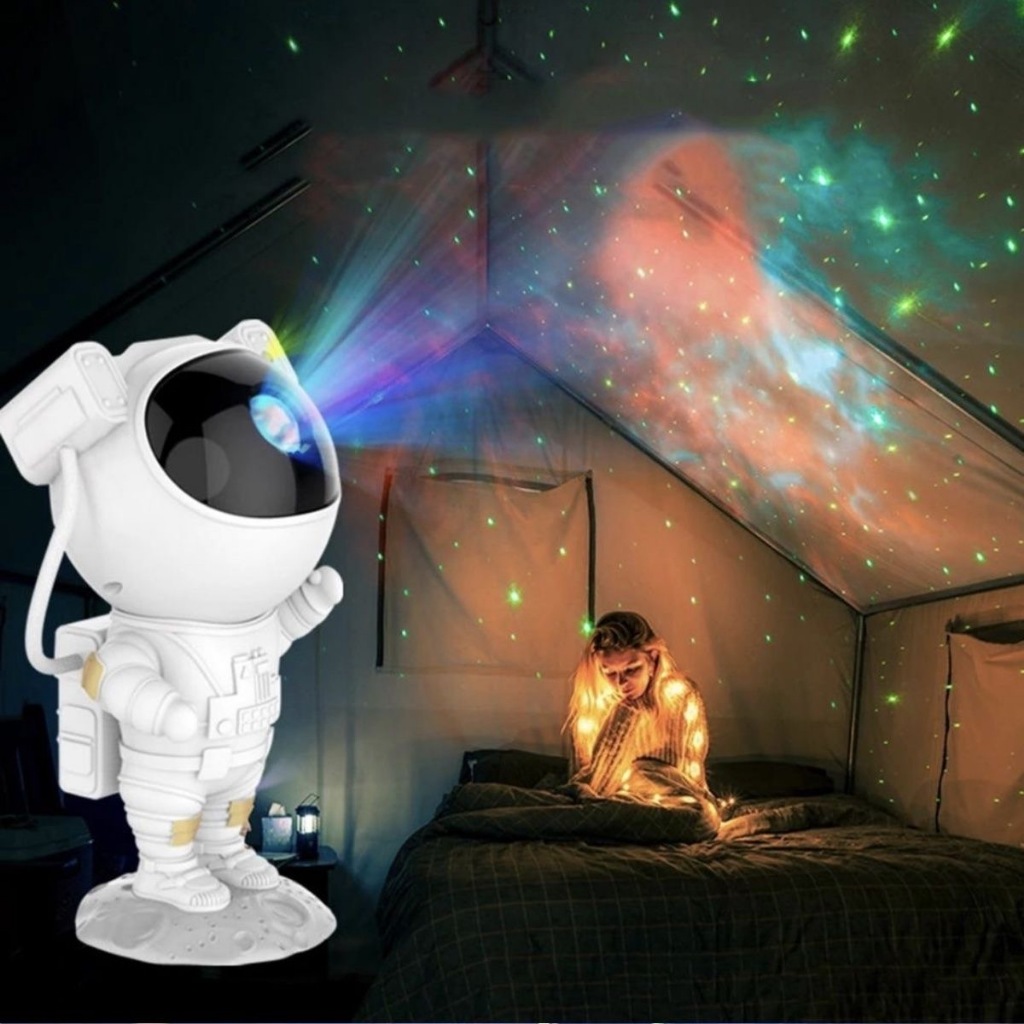 Projetor de galáxia infantil em formato de astronauta, projetando estrelas coloridas e nebulosas em um teto escuro. O astronauta está sentado, com a cabeça ajustável, e a projeção vívida ilumina o quarto de uma criança, criando um ambiente mágico e relaxante.