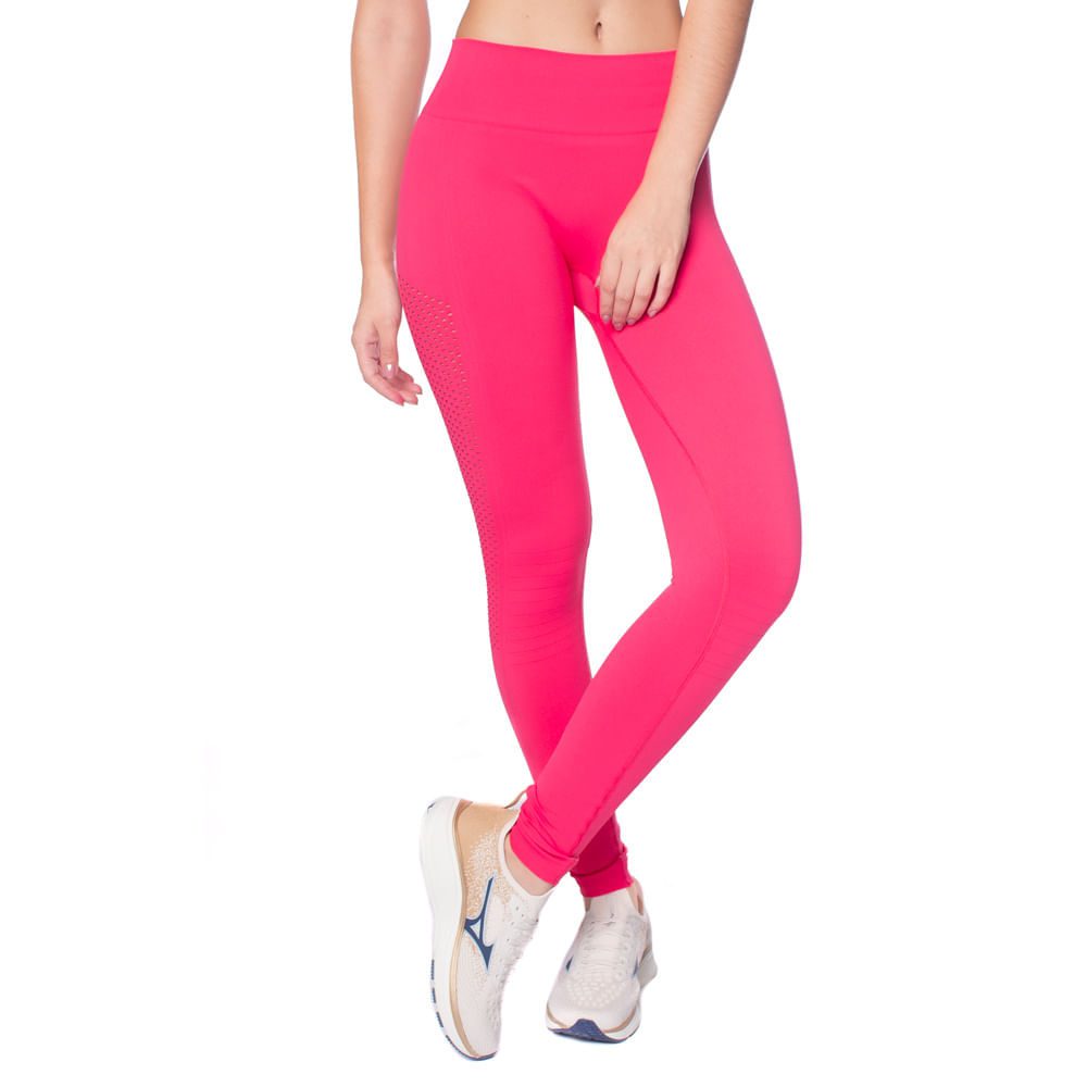 Modelo feminina em pose dinâmica, usando uma legging fitness sem costura de cor rosa escuro intensa, que destaca o design de cintura alta e o tecido texturizado, em ambiente de academia moderno e iluminado, exibindo flexibilidade e conforto para treinos de alta performance.